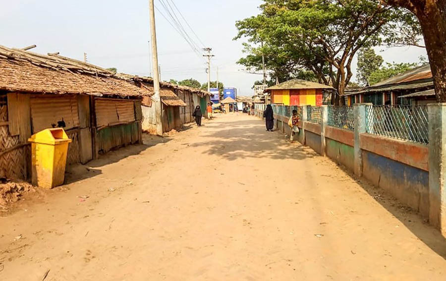 Rohingya refugees walk near closed shops on a deserted alley of a refugee camp during a government-imposed lockdown of Cox's Bazar district as a preventive measure against the COVID-19 coronavirus, in