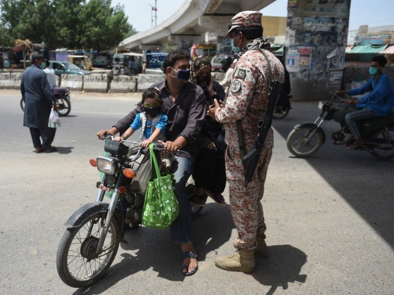 A Pakistani ranger stops motorcyclists as a preventive measure against the spread of Covid-19 after a provincial government ban on pillion riding during a government-imposed nationwide lockdown, in Ka